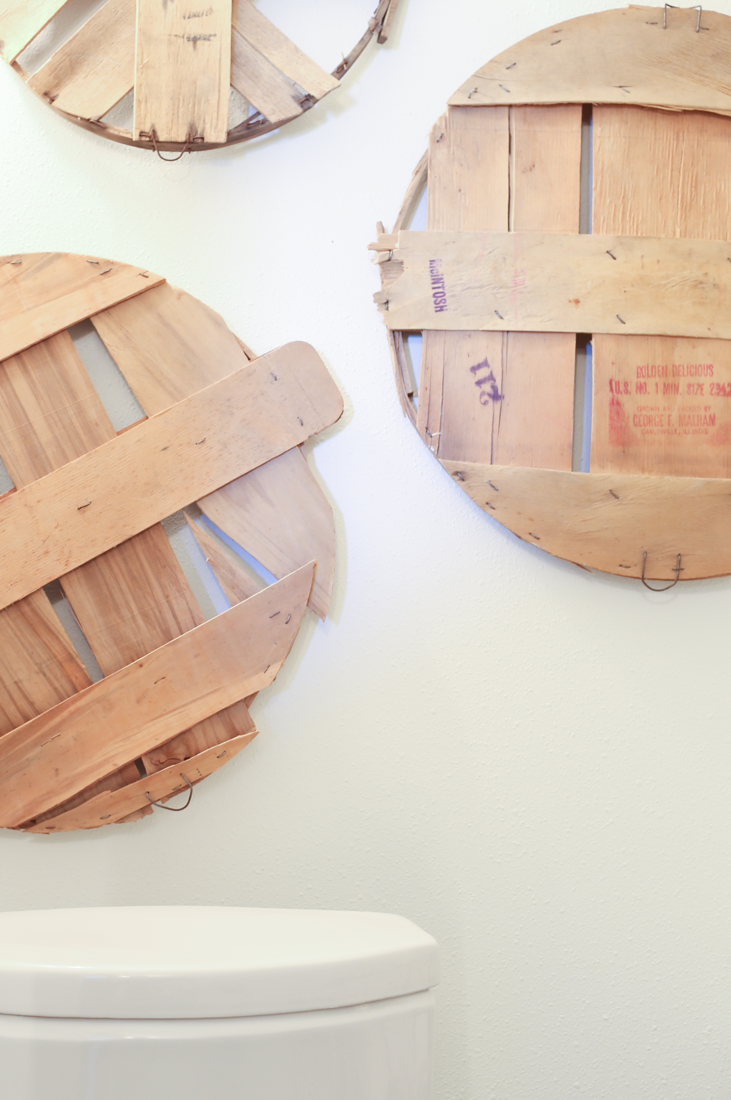 Apple barrel lids give texture and dimension to the wall and bring in the farmhouse look.