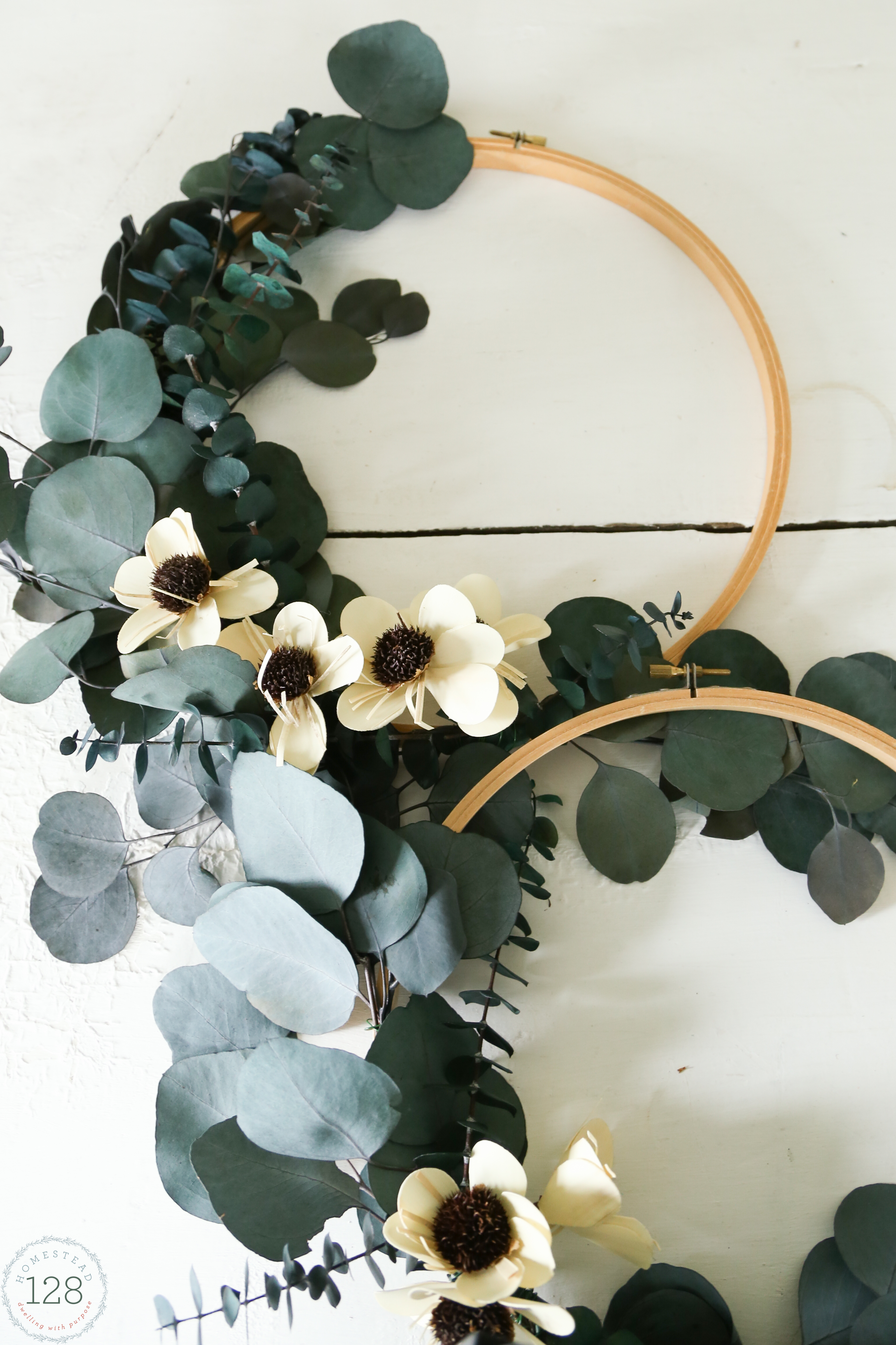 Create a wreath for the season with an embroidery hoop and dried natural stems.