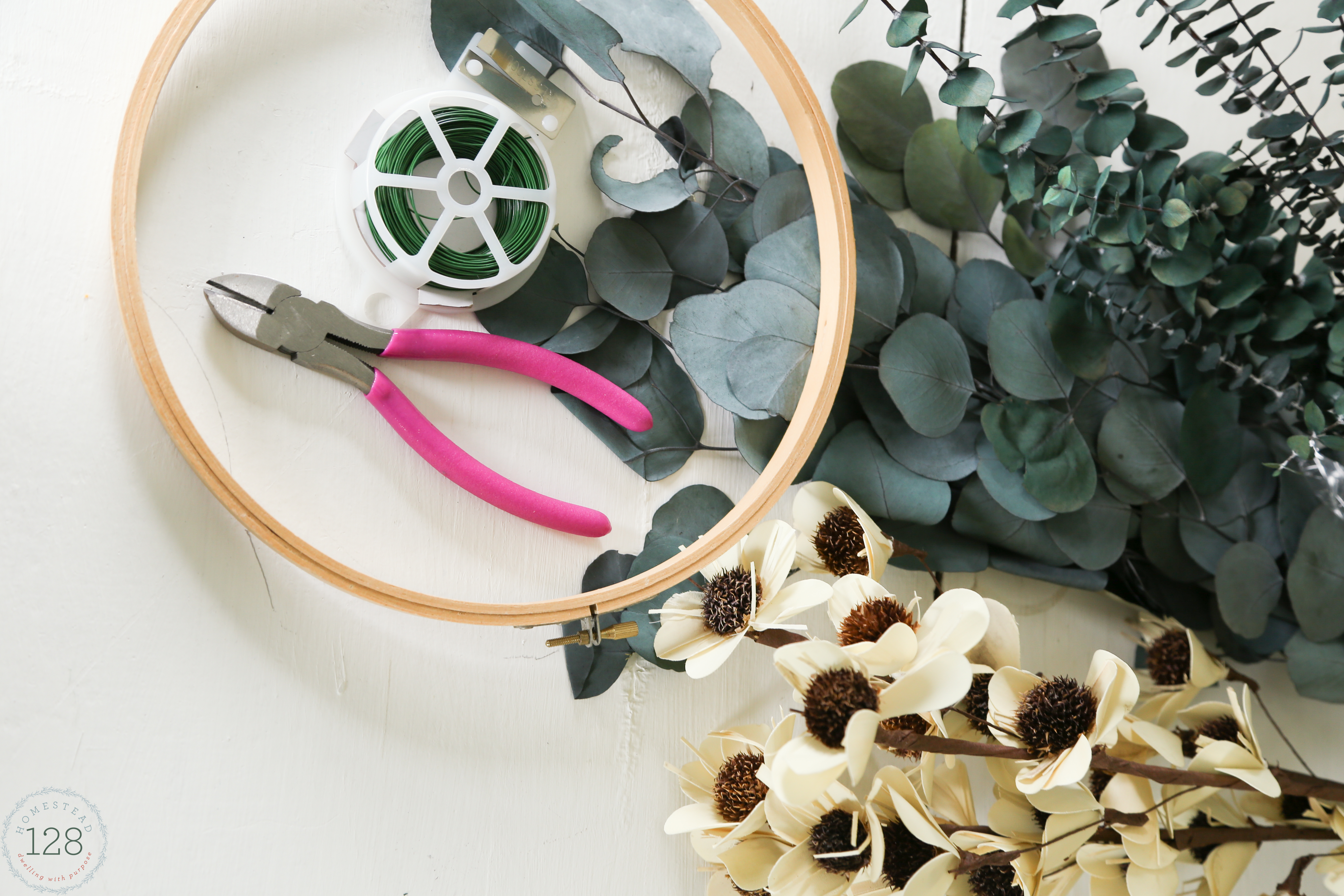 Eucalyptus and white flowered wreath made from embroidery hoops. An easy eucalyptus wreath DIY.