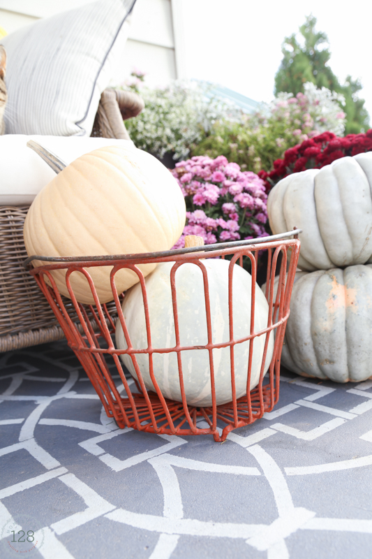 The red egg basket for storing pumpkins on the fall farmhouse front porch.
