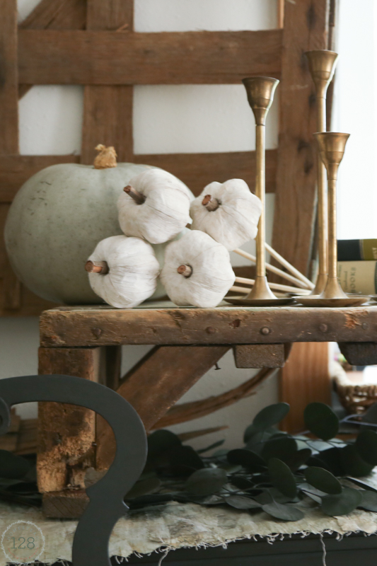 Rustic wood shelf with white and light green pumpkins for decorating the fall farmhouse.