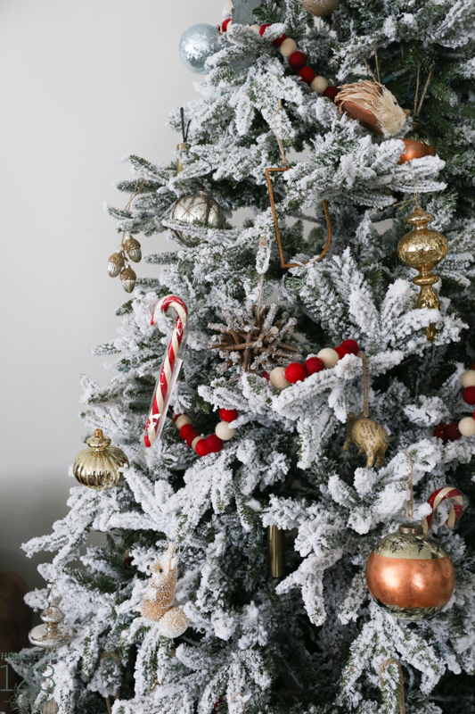 Farmhouse Christmas. A flocked Christmas tree is decorated with copper, gold and red. 