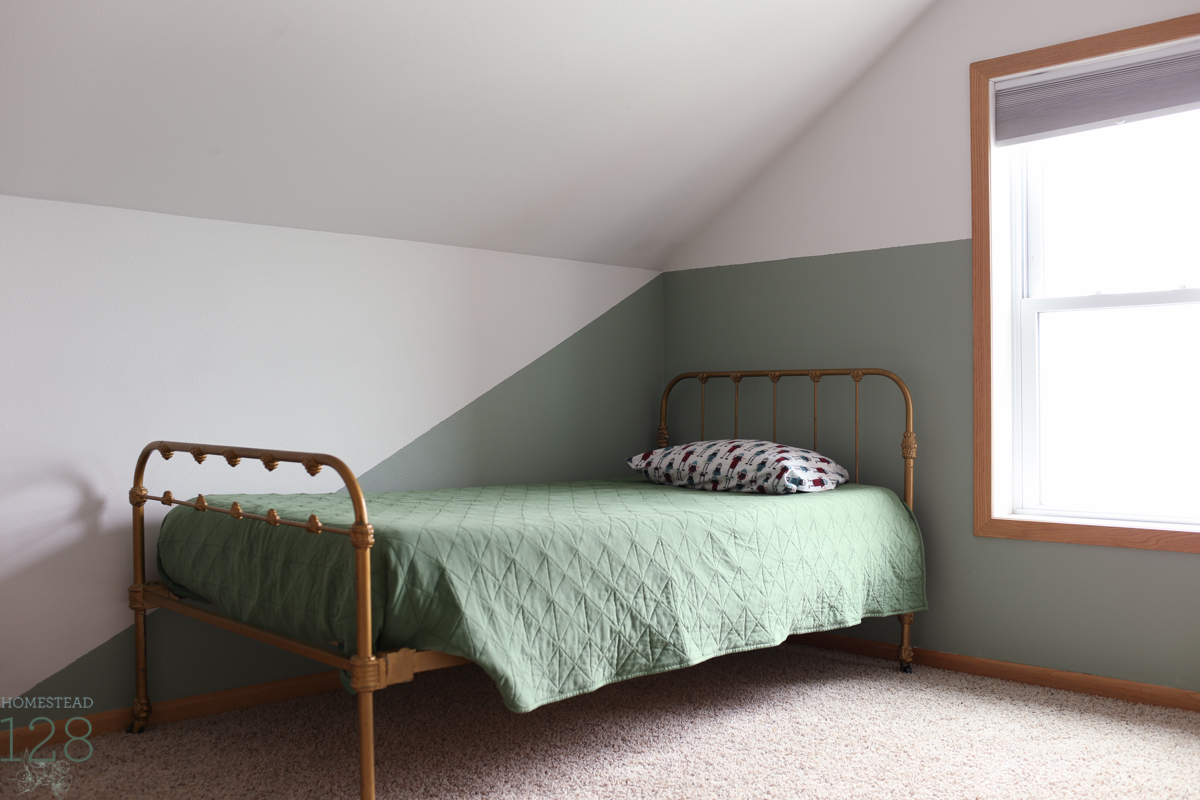 A modern twist on an accent wall in the shared boy's bedroom, complemented with a gold vintage bedframe.