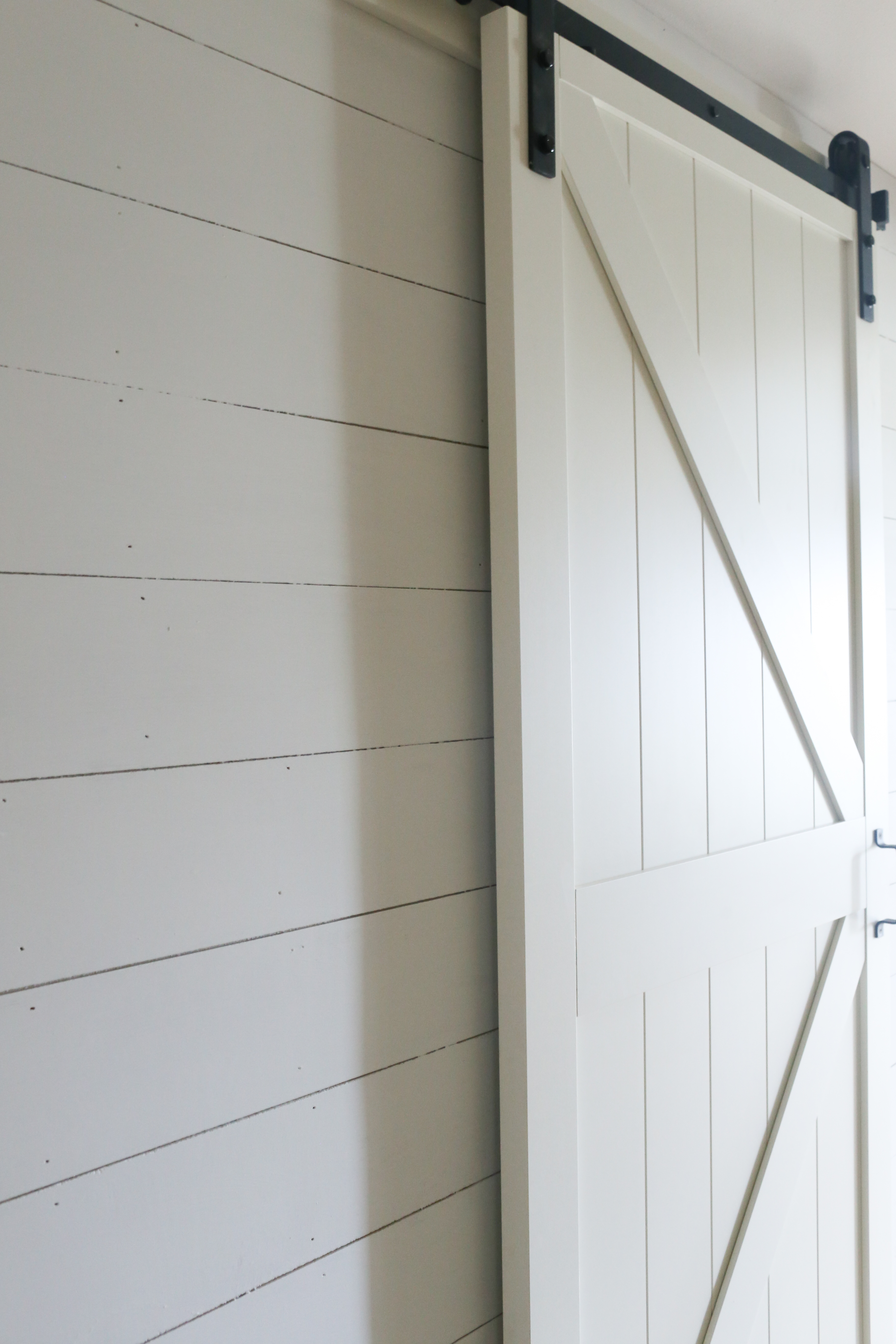 White faux shiplap and a sliding barn door gives the basic hallway a new look.